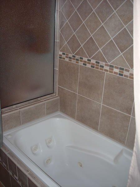 Custom ceramic tile backsplash with whirlpool tub